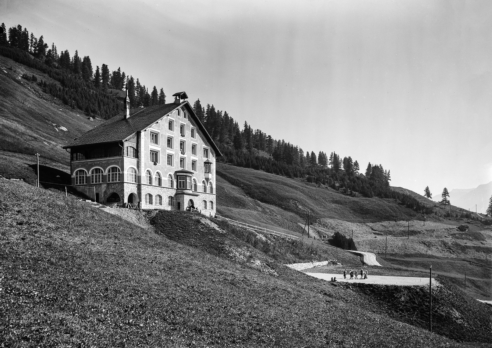 Aussenansicht des Kinderheims Belmunt in St. Moritz mit spielenden Kindern auf dem Platz vor dem Haus. Foto Gebrüder Wehrli 1912.