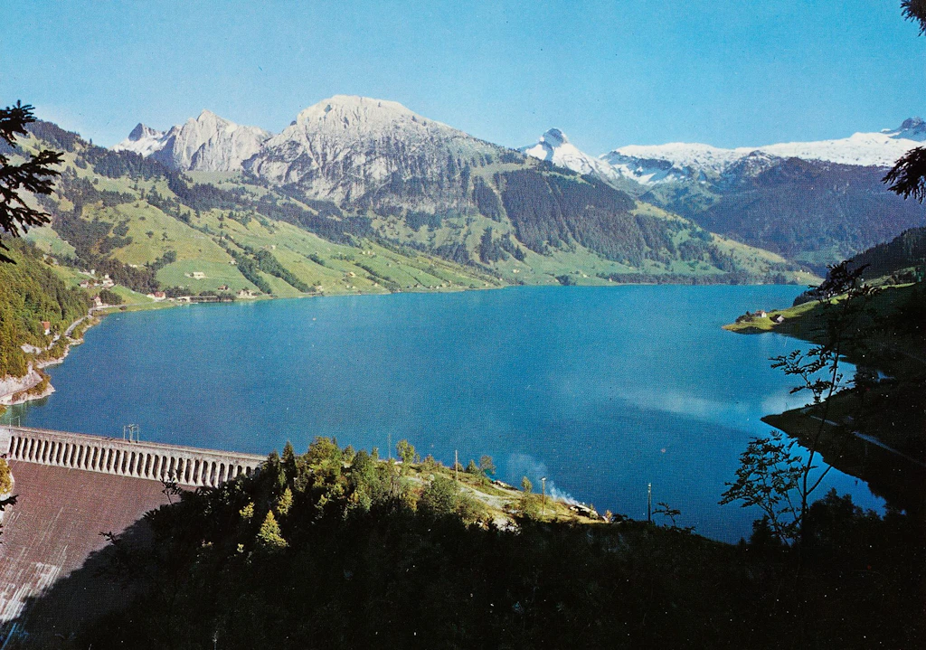 Luftaufnahme des Wägitaler Sees mit der Staumauer Schräh. Neu-Innerthal liegt nun höher als vorher. 