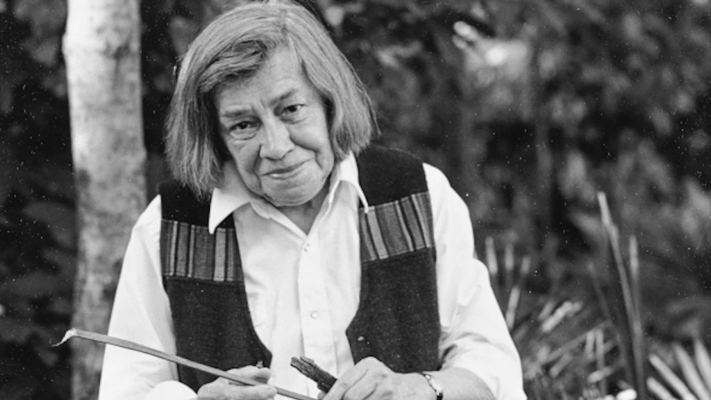 Fotografie: Patricia Highsmith sitzt in ihrem Wohnort Tegna an einem Granittisch und liest eine Zeitung