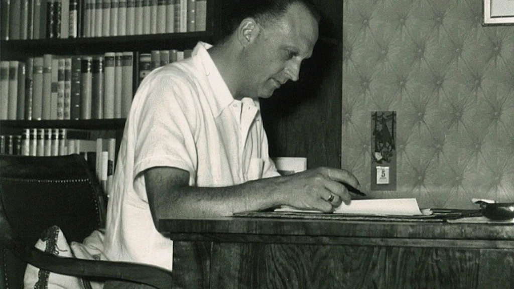 Hans Walter at his writing desk in Buchillon, with bookshelves in the background