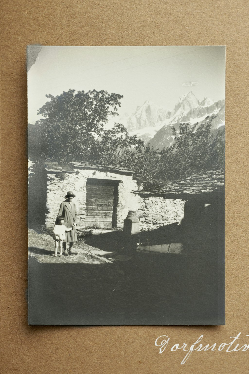 Excerpt from Album No. 6, a page dedicated to village snapshots from Soglio. Depiction of two people and a laundry house.