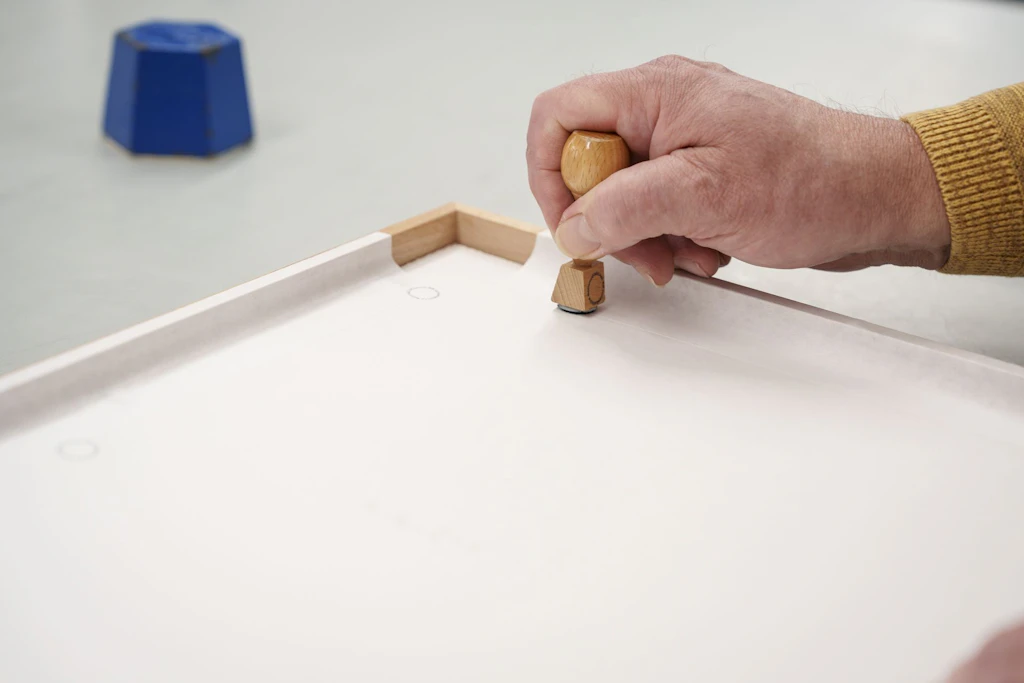 A National Library staff member applies a stamp to the back of the sealed mount.