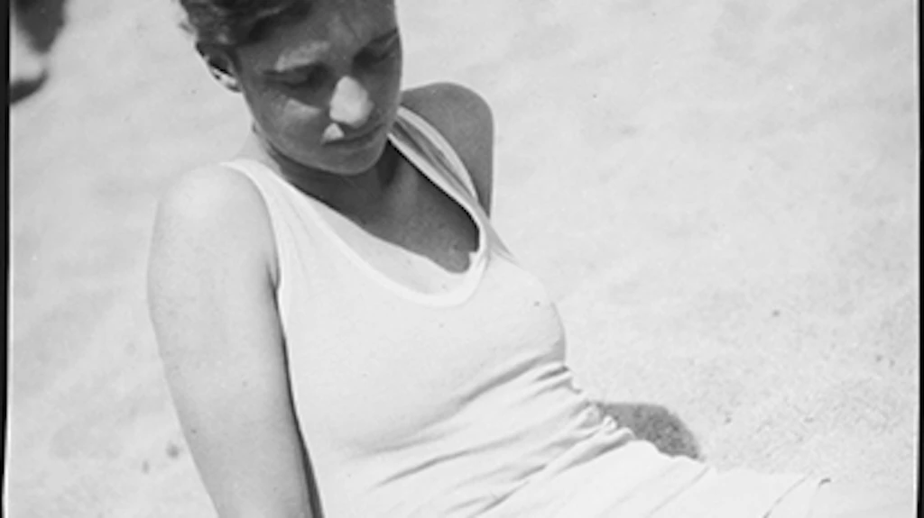 Half-length portrait of Annemarie Schwarzenbach sitting on the beach