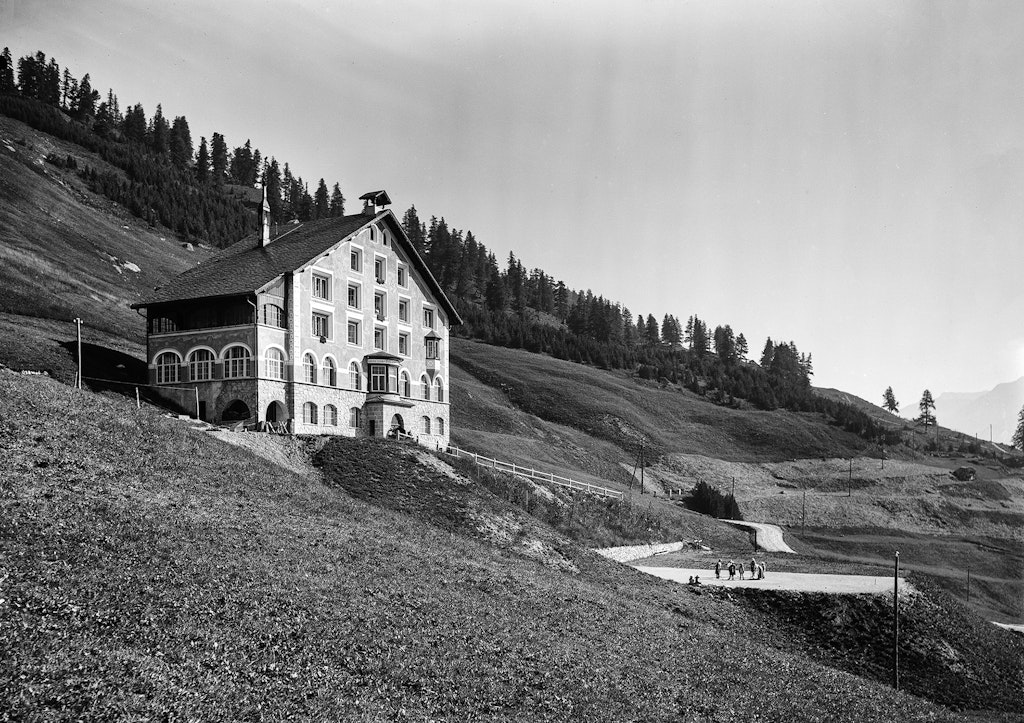 Vue extérieure du foyer pour enfants Belmunt, à Saint-Moritz, avec des enfants qui jouent sur le terrain devant le bâtiment. Photo : frères Wehrli, 1912.