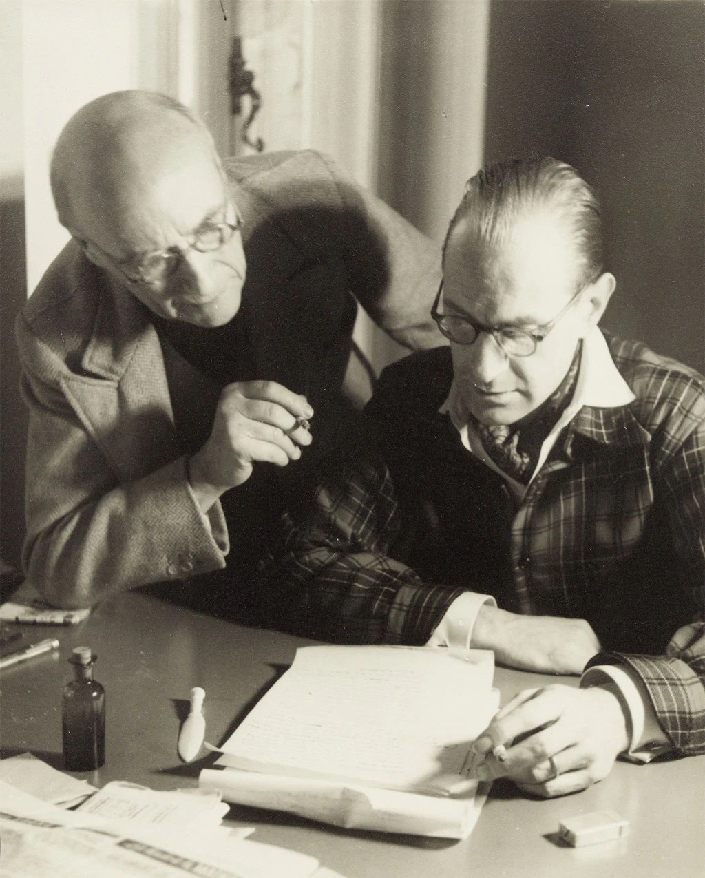 André Gide, avec lunettes, et Richard Heyd, lisant ensemble un manuscrit, chez l'éditeur, en 1947.