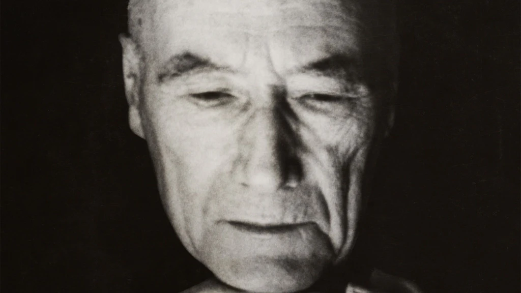 André Gide en gros plan, de face, les mains jointes sous le menton, les yeux baissés, 11 septembre 1946.