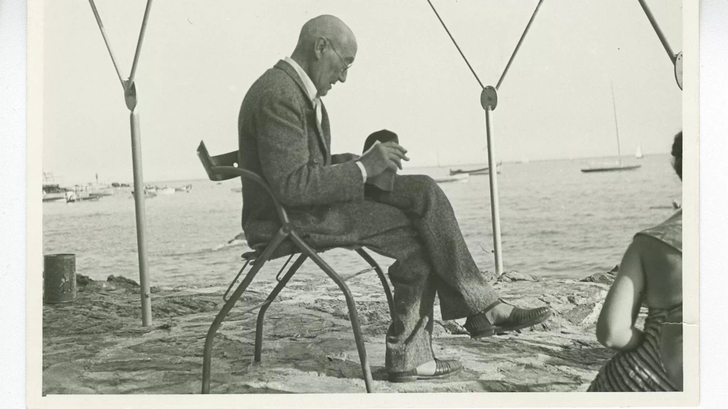 André Gide, avec lunettes, lisant sur une plage à Rapallo (Italie), en juillet 1950. Image provenant du Fonds André Gide des Archives littéraires suisses, Berne.