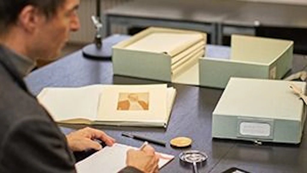 Une personne consulte les archives du Cabinet des estampes.