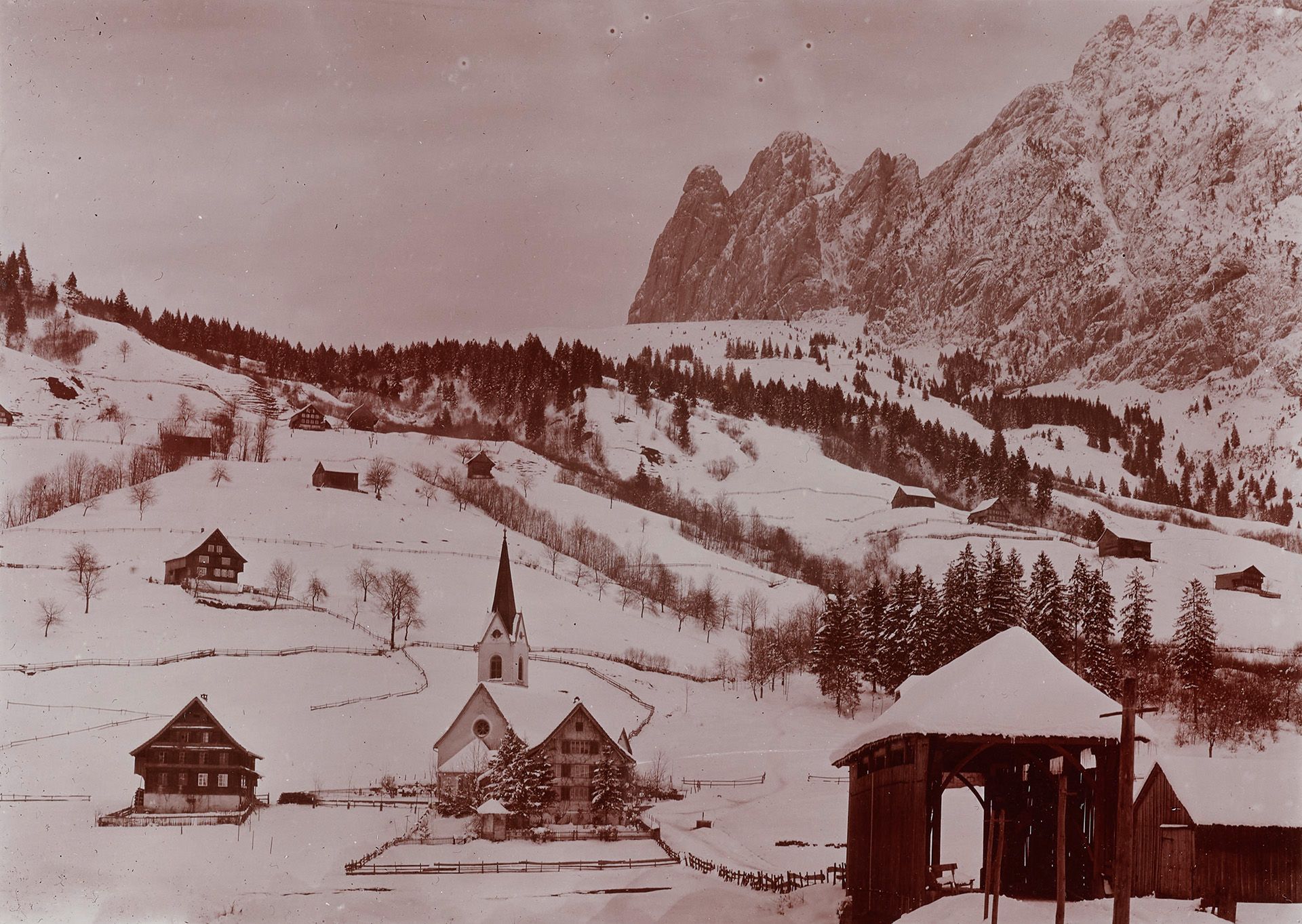 Vue sur le village d’Innerthal, dans le canton de Schwytz, avec son église paroissiale et son pont couvert en bois, avant 1920.