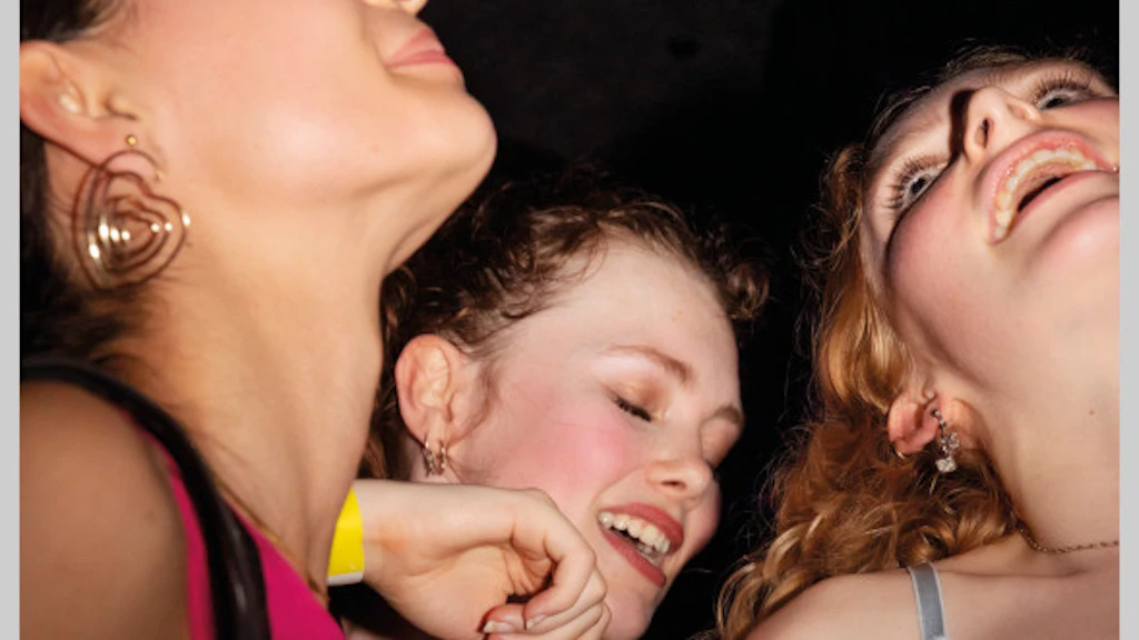 Fotografia di tre giovani donne che festeggiano in modo vivace.